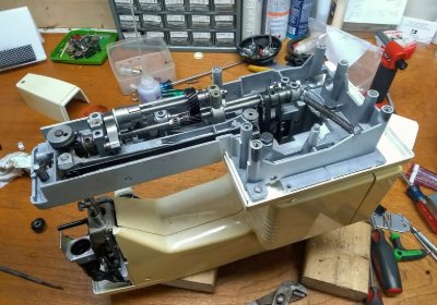 A sewing machine disassembled on the bench for gear replacement
